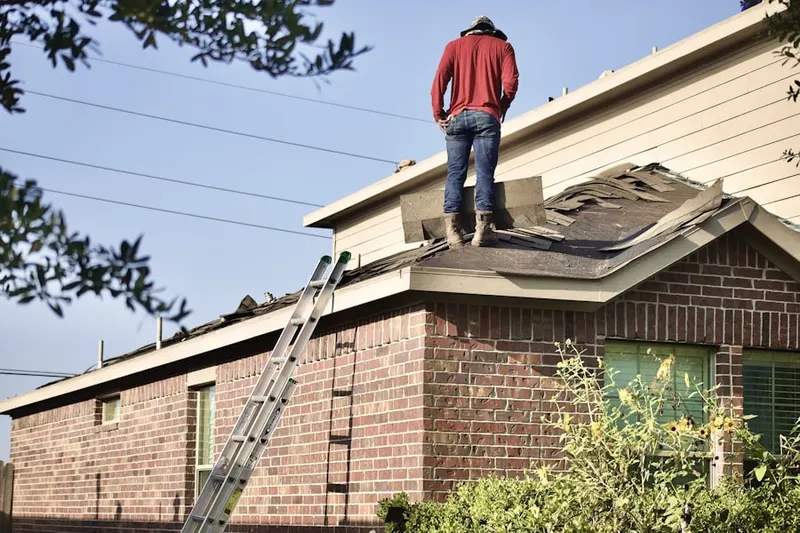 Professional roofer working on a residential roof in Heather Knoll
